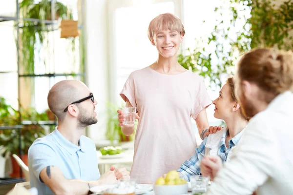 Gelukkig Meisje Met Glas Water Kijken Naar Haar Vrienden Door — Stockfoto