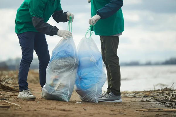 さらに活用のための特別な袋にごみを梱包組織の保存の生態から二人の男 — ストック写真