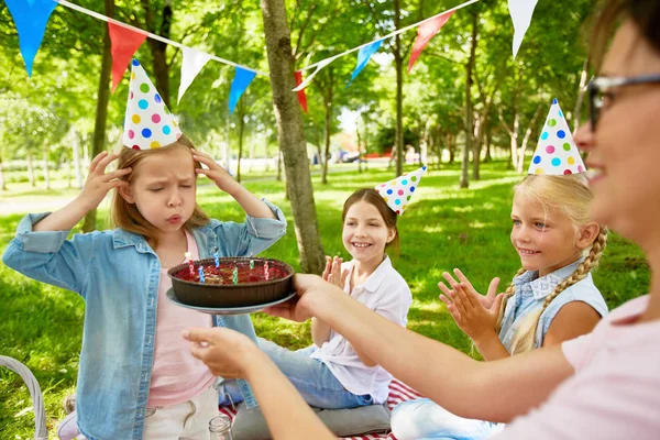 若い女性によっての夏のピクニックの週末開催の誕生日ケーキの上六つの蝋燭を吹く少女 — ストック写真