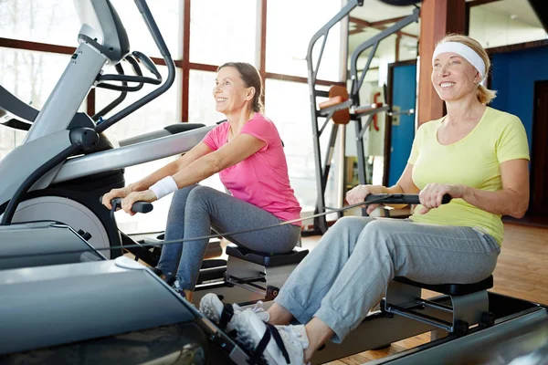 Twee Gelukkige Senior Vrouwen Training Roeitoestellen Hedendaagse Leisure Center — Stockfoto
