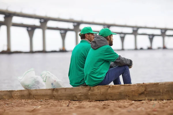 Dwóch Facetów Mundurze Greenpeace Siedząc Brzegu Rzeki Przez Wody Worków — Zdjęcie stockowe