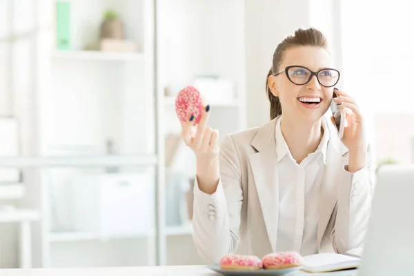 Vrolijke Jonge Zakenvrouw Zitten Door Bureau Voor Laptop Lekkere Donuts — Stockfoto