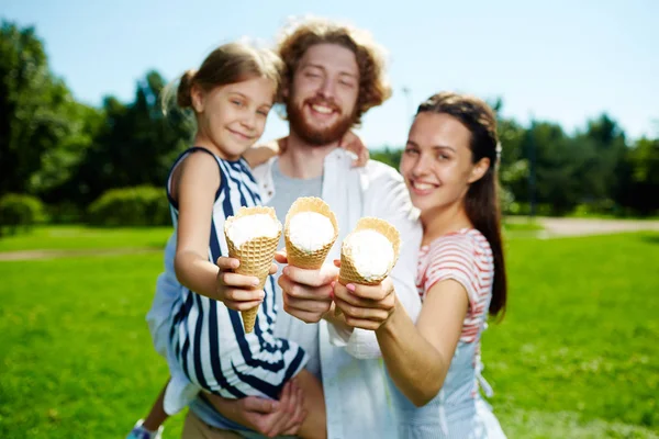 快乐的年轻父母和他们的女儿显示锥体各式各样 而在公园里度过夏天的一天 — 图库照片