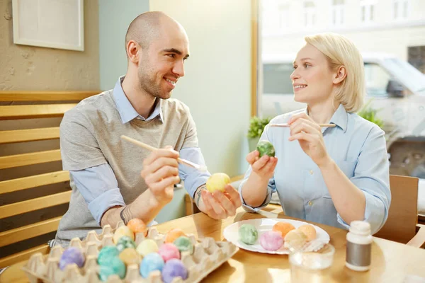 Młoda Para Siedzi Przy Stole Przygotowania Jaj Świętowania Wielkanocy — Zdjęcie stockowe