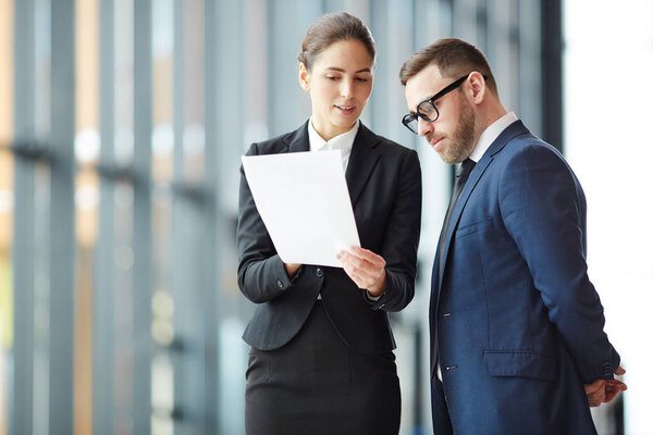 Молодой агент с бумагой, объясняющей условия контракта своему клиенту или деловому партнеру на встрече
