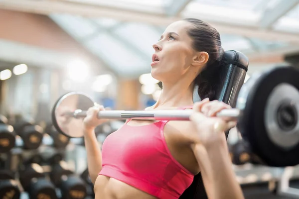 Jovem Mulher Tentando Levantar Pesado Barbell Seu Peito Enquanto Exercitando — Fotografia de Stock