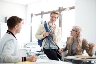 Sırt çantası ile mutlu adam mola da sınıfta onun en sevdiği konu hakkında üniversite arkadaşları yla konuşurken