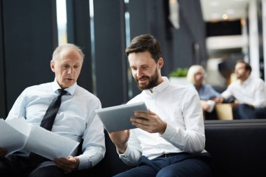 Toplantıda online finansal veri veya istatistikler bakarak formalwear iki işadamı