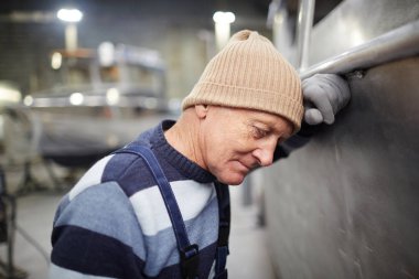 İnşa ettiği yeni teknenin duvarına yaslanan kıdemli mühendis