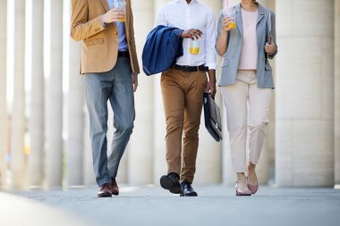 Sokakta yürüyen ve mola sırasında konuşan smoothie kupaları ile tanınmayan iş adamlarının yakın çekim