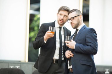 İçecekleri olan iki zarif işadamı ziyaret ettikleri restoranda tuhaf bir şeyi tartışıyorlar.