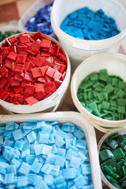 Mozaik atölyesinde çalışmaya hazır renkli kare karolar ile birkaç sepet üst görünümü, kopya alanı arka plan