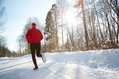Spor giyim kış orman kar yolda çalışan etkin insanın arkadan görünüm