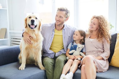 Neşeli baba, anne ve küçük kızı ev dinlenme tadını çıkarırken onların safkan evcil hayvan bakarak