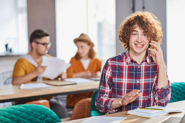 Jovem Especialista Feliz Com Smartphone Chamando Enquanto Sentado Mesa Organizando — Fotografia de Stock