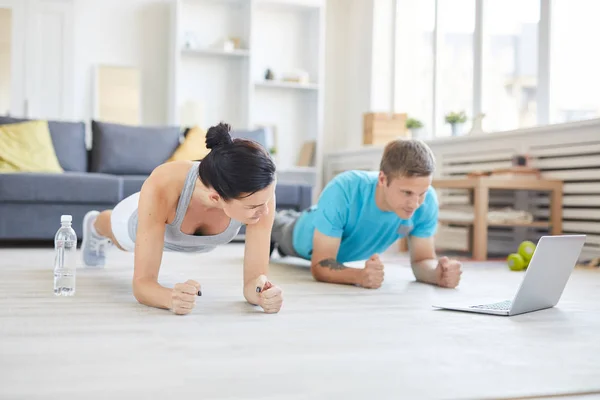 Contemporary Young Active Couple Sportswear Doing Planks Floor Front Laptop — Stock Photo, Image