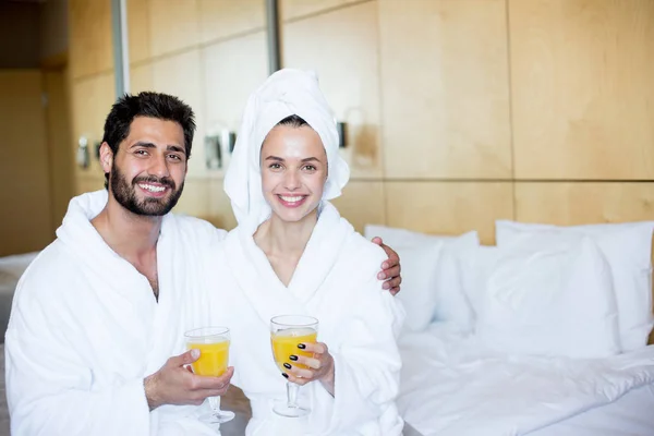 Jovem Feliz Casal Afetuoso Roupões Banho Sentado Quarto Tomando Suco — Fotografia de Stock