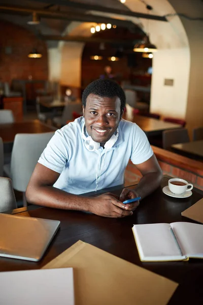 Młody Biznesmen Smartfonem Patrzy Ciebie Siedząc Przy Stole Kawiarni — Zdjęcie stockowe