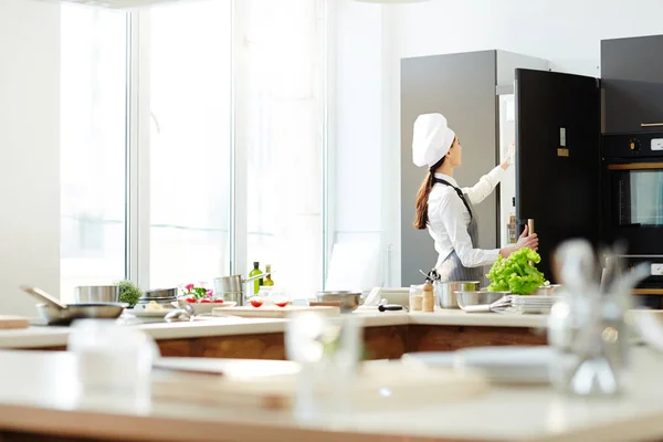 Bakifrån Upptagen Kvinnlig Hatt Och Förkläde Öppna Kylskåp Och Ingredienser — Stockfoto