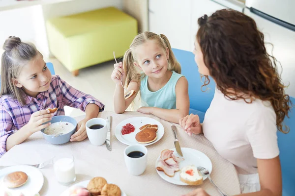 Små Bedårande Flickor Tittar Sin Mamma Med Frukost Medan Äter — Stockfoto