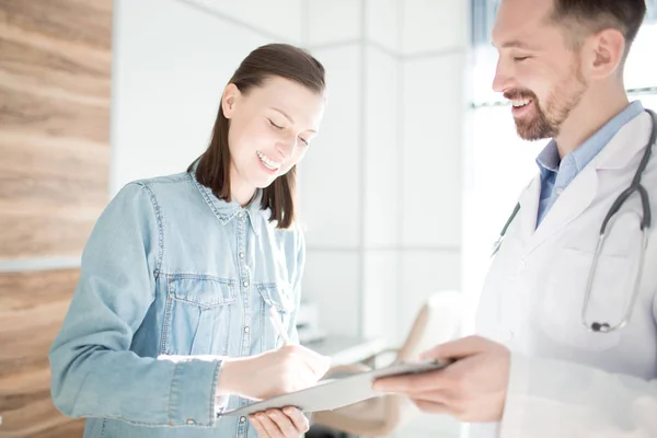 Zufriedene Patientin Unterschreibt Medizinische Papiere Nach Rücksprache Mit Ihrem Arzt — Stockfoto