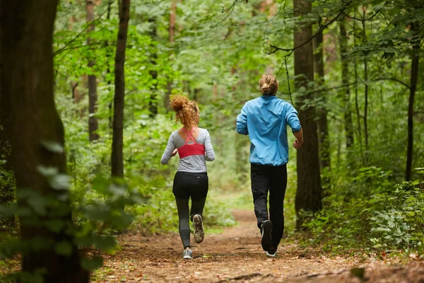 年轻运动员和女运动员在森林中跑步锻炼的后视图 — 图库照片