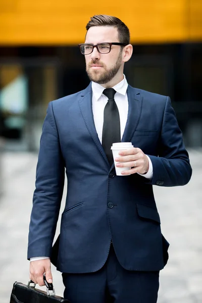 穿着商务服装的年轻而成功的英俊男性 戴着眼镜 手里拿着一杯热饮 望着远方 — 图库照片