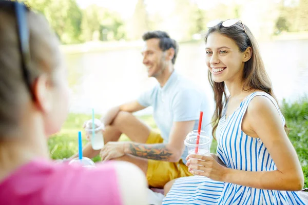 Jovem Feliz Com Bebida Conversando Com Dos Amigos Piquenique Verão — Fotografia de Stock