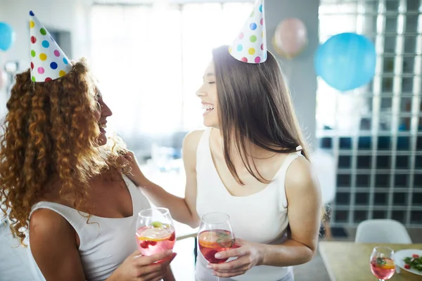 誕生日パーティーで楽しみながら笑う飲み物を持つ2人の楽しいフレンドリーな女の子 — ストック写真
