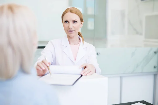 Clínico Confiante Consultando Seu Paciente Apontando Para Documento Enquanto Pede — Fotografia de Stock