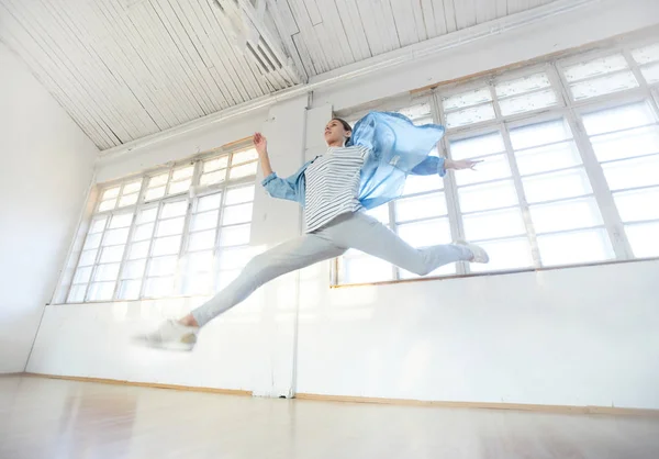 ワークアウト中にモダンなスタジオの床を飛び越えてレッグウエアのエネルギッシュなブレイク ダンサー — ストック写真