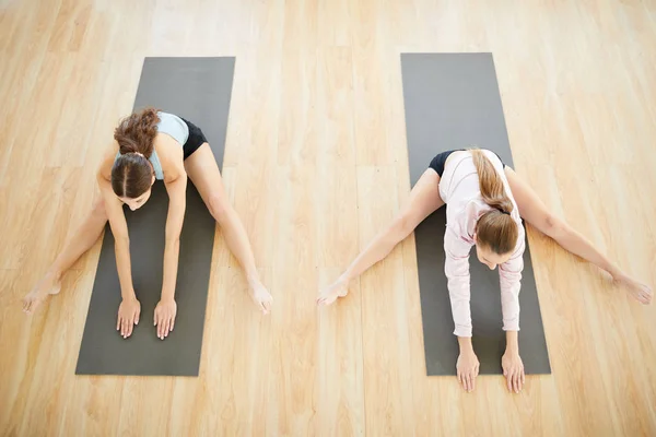 Zwei Junge Frauen Mit Ausgestreckten Beinen Die Sich Bei Schwierigen — Stockfoto