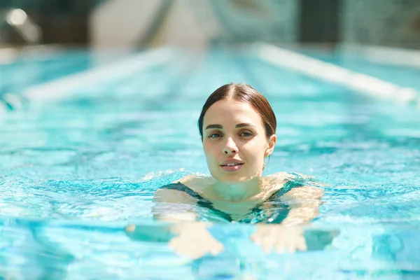 Mujer Bastante Joven Nadando Piscina Mirando Cámara Mientras Pasa Día —  Fotos de Stock
