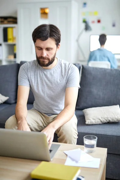 Ung Man Sitter Soffan Vardagsrummet Och Bläddrar Nätet Som Hemmakontor — Stockfoto