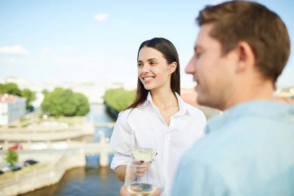 愉快的沉思的年轻夫妇看着远离 并在约会喝白葡萄酒 而站在屋顶上庆祝周年 — 图库照片