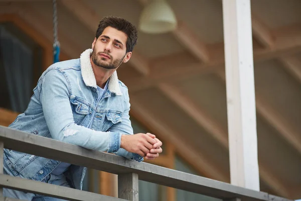 Content Dreamy Young Man Warm Denim Jacket Leaning Railing Looking — Stock Photo, Image