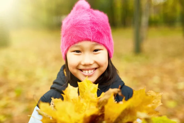 Молодая Девушка Ярко Розовой Шапочке Смотрит Тебя Кучи Желтых Листьев — стоковое фото
