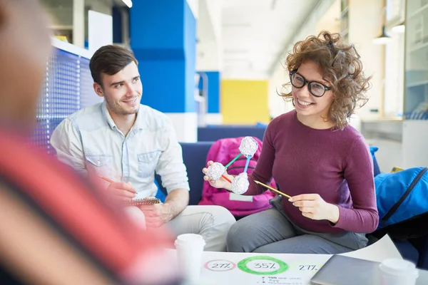 Uśmiechnięta Studentka Wskazująca Model Cząsteczki Podczas Pracy Nad Projektem Naukowym — Zdjęcie stockowe