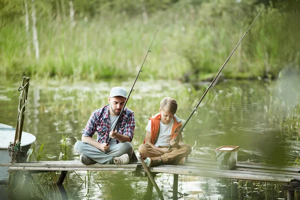 Papà Figlio Seduti Sul Molo Con Canne Pesca Sul Fiume — Foto Stock