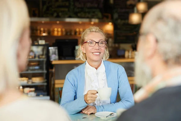 Glückliche Blondine Mit Zahmem Lächeln Beim Tee Mit Ihren Freunden — Stockfoto