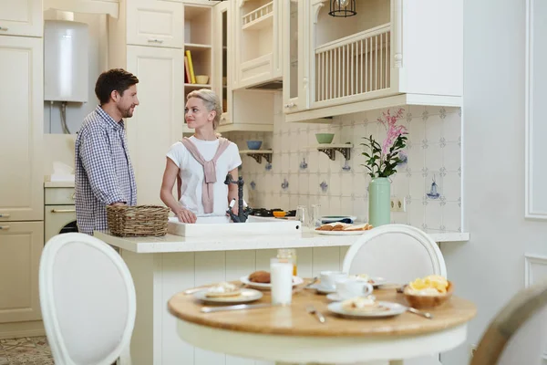 Lächelndes Junges Paar Lässiger Kleidung Das Küchentisch Steht Und Miteinander — Stockfoto