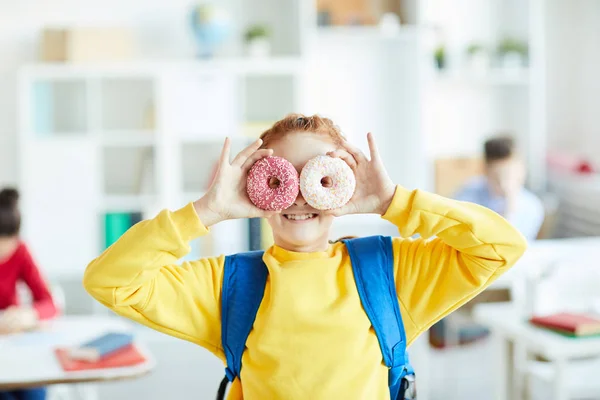Vrolijk Schoolmeisje Met Rugzak Die Twee Donuts Voor Haar Ogen — Stockfoto
