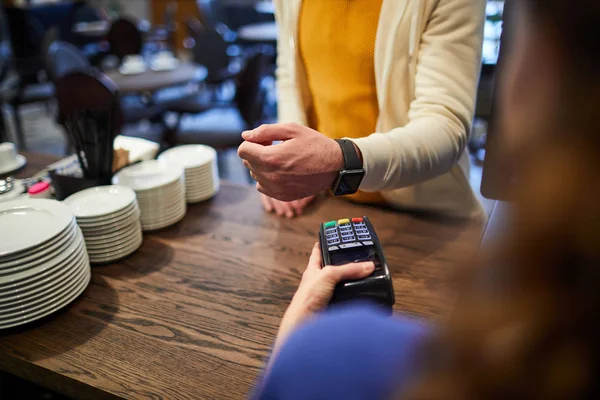 带智能手表的客户在支付机上保持手腕 同时在咖啡馆支付订单 — 图库照片