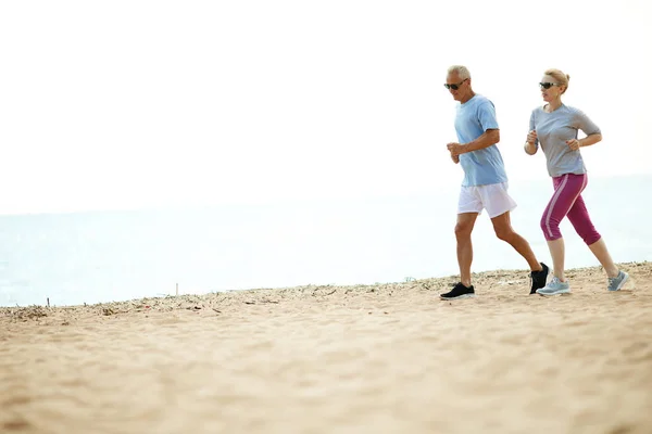 Åldrad Man Och Kvinna Fritidskläder Jogging Sand Strand Längs Stranden — Stockfoto