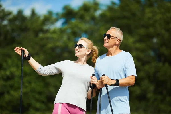 Active Aged Woman Sunglasses Offering Her Husband Trekking Farther — Stock Photo, Image