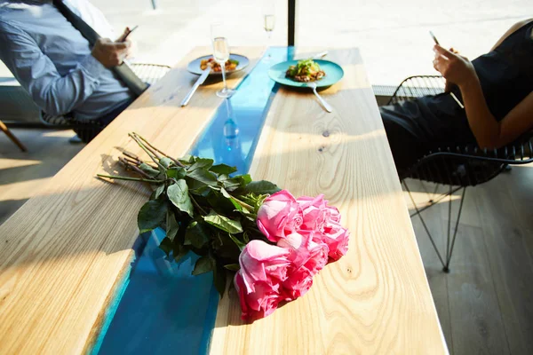 Rosas Rosadas Frescas Mesa Com Comida Servida Casal Viciado Gadgets — Fotografia de Stock