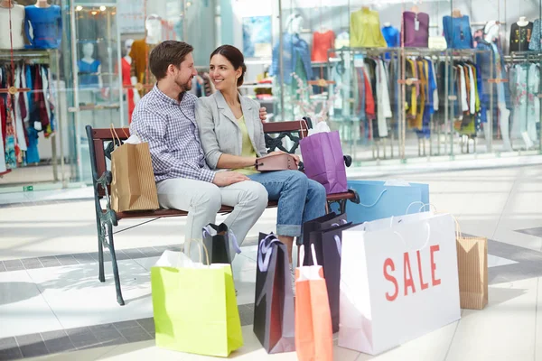 Young Couple Surrounded Paperbags Sitting Bench Enjoying Time Mall — Stock Photo, Image