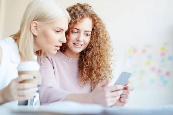 Colegas Jovens Positivas Vendo Notícias Internet Smartphone Discutindo Isso Enquanto — Fotografia de Stock