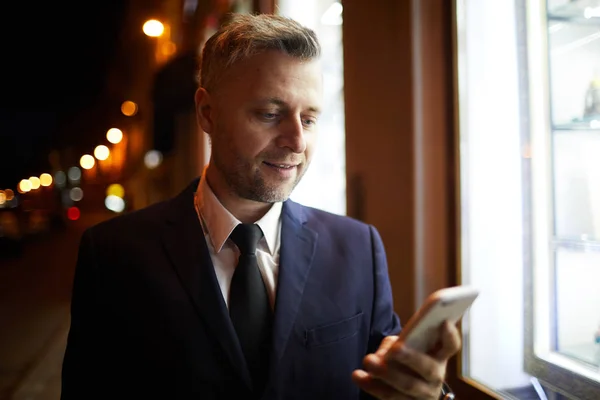 Geschäftsmann Mit Smartphone Steht Vor Schaufenster Eines Nachtgeschäfts Während Städtischen — Stockfoto