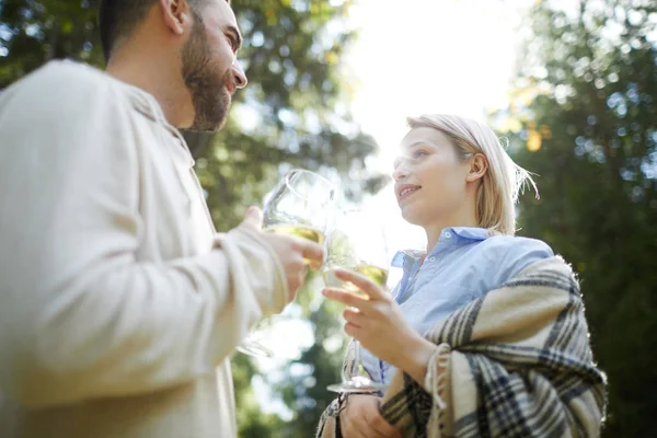 若い愛する白人のカップルの低角度のビュー屋外で白いワインのグラスを金貨 礼拝でお互いを見て — ストック写真